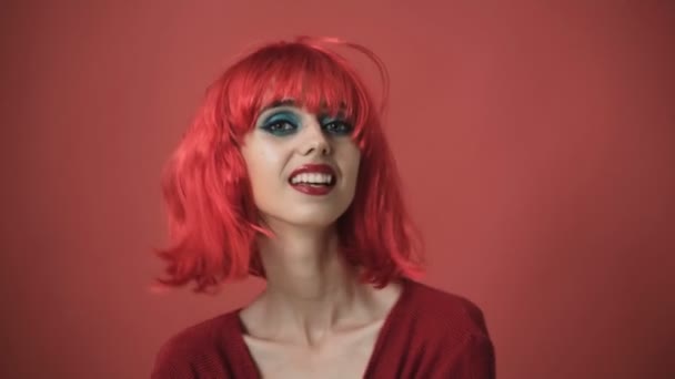 戴红假发的漂亮女孩 一个年轻的女孩在演播室的背景 穿着红色假发的时髦女孩 — 图库视频影像