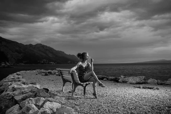 Frau mit Wein am Abendstrand — Stockfoto