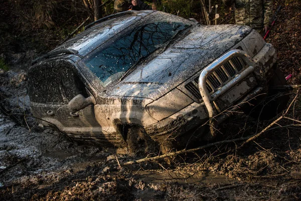 SUV covered with mud on path with deep rut. — Stock Photo, Image