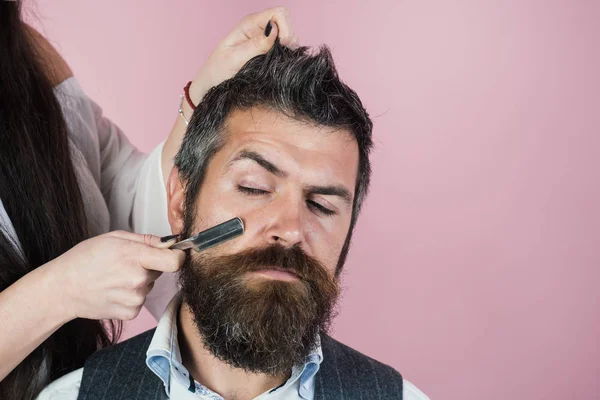 Homem barbudo beber uísque, mulher sexy com cabelo encaracolado longo . — Fotografia de Stock