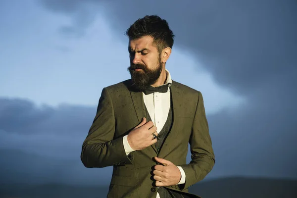 Hipster con aspecto elegante frente al cielo dramático, horizonte . — Foto de Stock