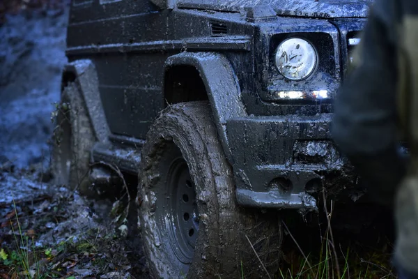 Dirty offroad pneumatiky zastříkaný blátem. Součástí vůz uvízlý — Stock fotografie