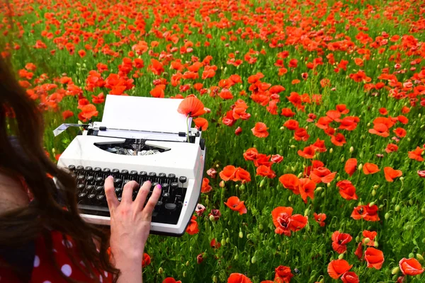 Empreintes de main humaine sur une machine à écrire rétro dans le champ de pavot — Photo