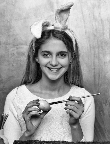 Happy easter girl in bunny ears with egg and paintbrush — Stock Photo, Image