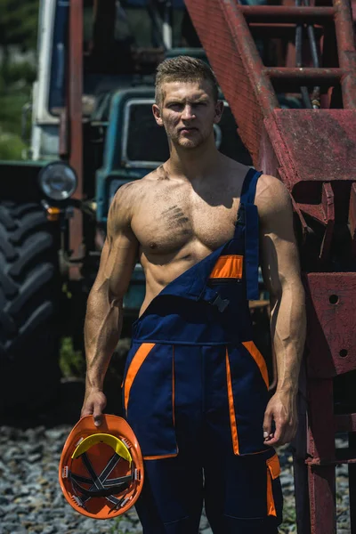 Sexy man with nude torso near construction equipment or excavator — Stock Photo, Image