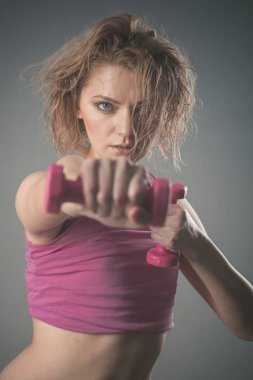 Kadın Koç ile katı yüz tutan dumbbells? n gri arka plan,