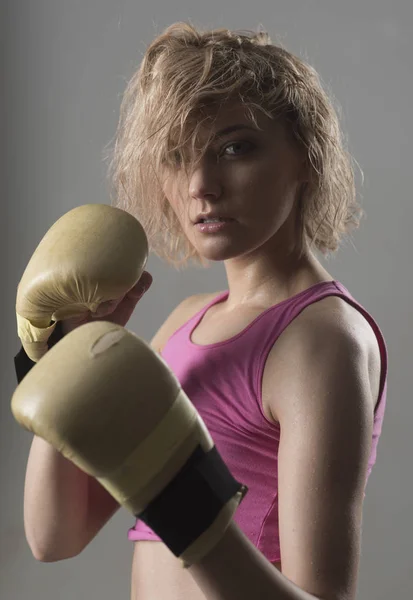 Fitness trainer or sportive lady boxing, training hard.