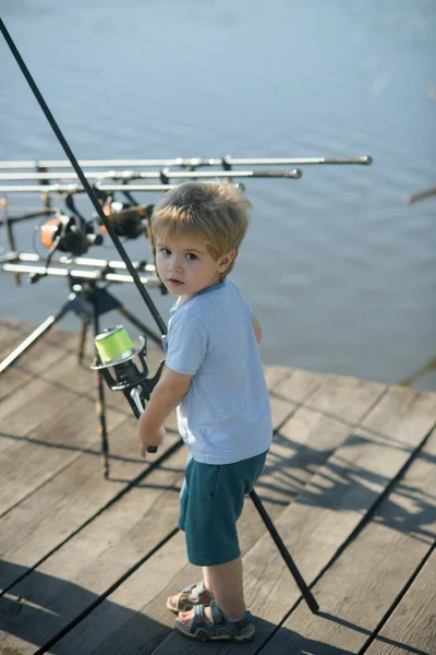 Liten pojke lär sig att fånga fisk i sjö eller flod — Stockfoto