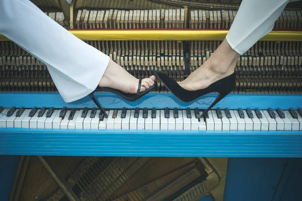 Ноги на клавіатурі піаніно синій колір, мода . — стокове фото