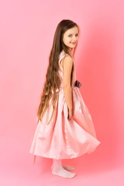 Niña con pelo largo sobre fondo rosa . — Foto de Stock