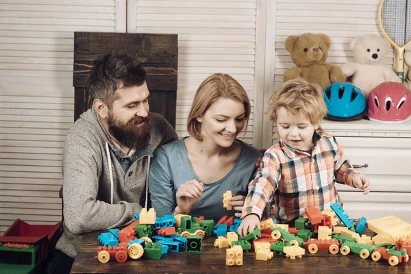 父母和孩子快乐的面孔举行五颜六色的砖. — 图库照片