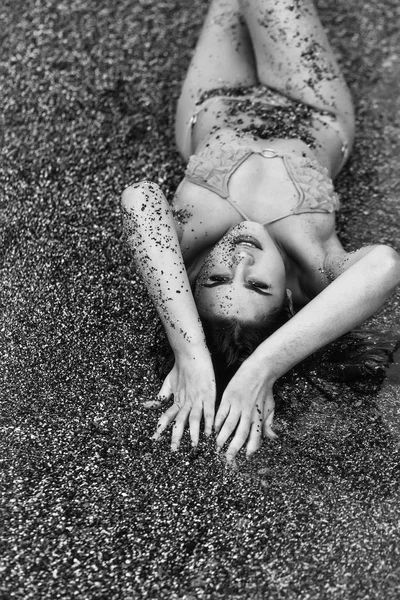 Pretty girl lies in yellow swimsuit on sea beach — Stock Photo, Image