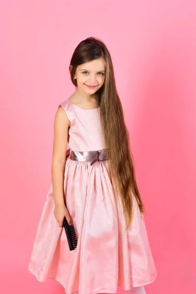Girl child brush hair in fashionable dress on pink. — Stock Photo, Image