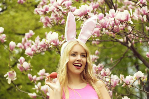 Gelukkig meisje in bunny oren lachen met rode ei — Stockfoto