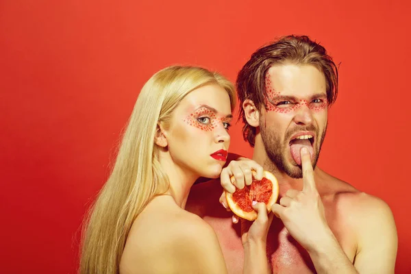 Пара летом, грейпфрут в руке мужчины рядом с женщиной — стоковое фото