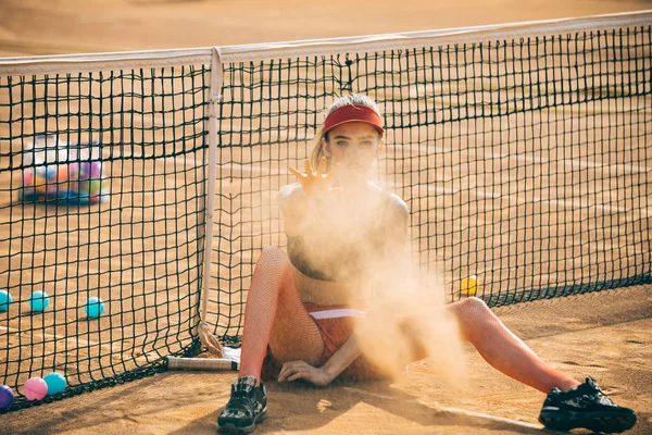 Deporte mujer lanzar arena en pista de tenis — Foto de Stock