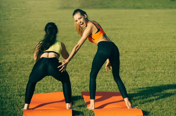 Las mujeres de energía hacen ejercicios atléticos sobre hierba verde —  Fotos de Stock