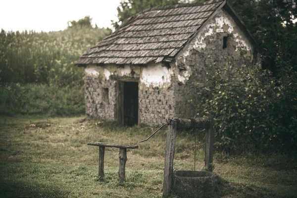 Hausbaracke mit altem Brunnen im Hof — Stockfoto