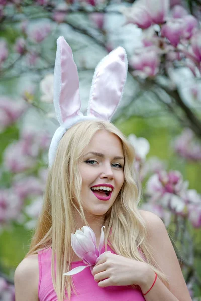 Vrouw die lacht met schattige bunny oren op magnolia — Stockfoto