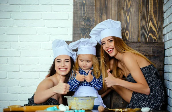 Menino e meninas em chapéus chef dando polegares para cima — Fotografia de Stock