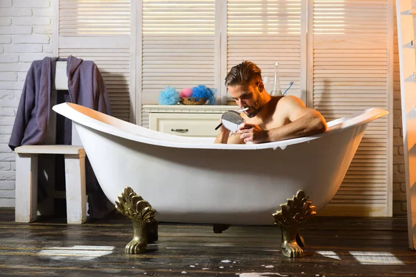Молодой человек бреется в ванной — стоковое фото