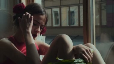 Çekici kadın bir pencereden dışarı bakıyor. Güzel kız bir pencereden dışarı bakıyor. Ot pencereden bakıyor ve gelecek hakkında rüya kız.