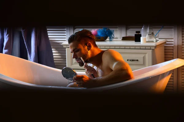 ヒゲを剃る石鹸とマッチョはミラーで見てください 髭の男は浴室でお風呂でカミソリで剃る シェービングは 理容室 理髪店 スキンケア グルーミング — ストック写真