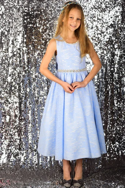 銀色の背景に青いドレスでかわいい女の子 — ストック写真