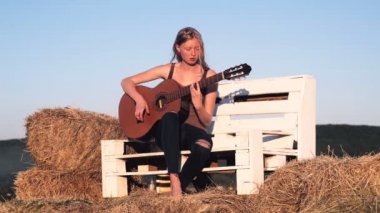 Kız gitar çalmak. Parçası. Kadın Sunset'teki gitar çalmak.