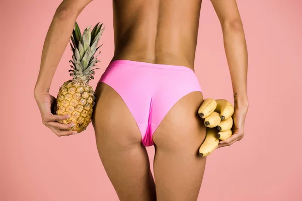 Fesses de fille en bikini avec banane et ananas — Photo