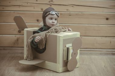 bir karton kutunun içinde uçan çocuk pilot