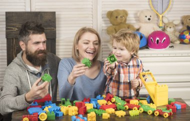 Baba, anne ve oğul açık tahta arka planda oyun odasında..