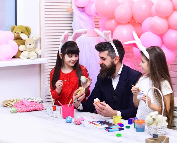 Father and daughters paint handmade egg.