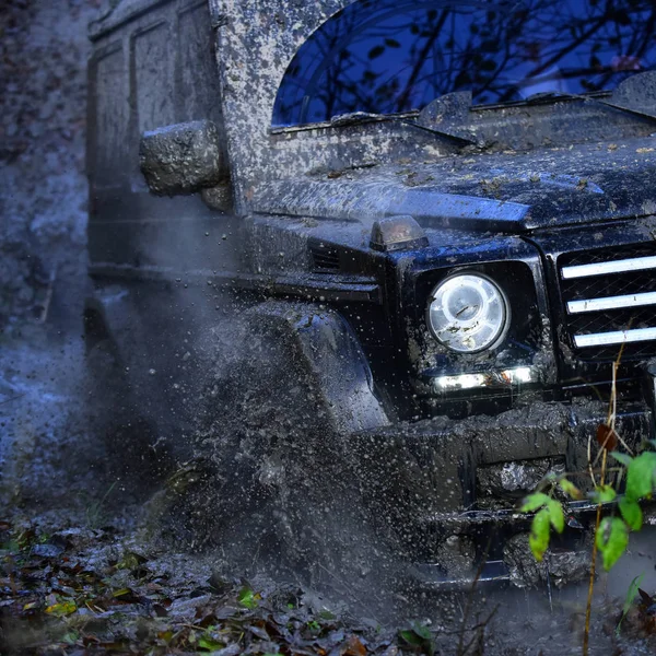 Black crossover driving with splash through dirt. — Stock Photo, Image