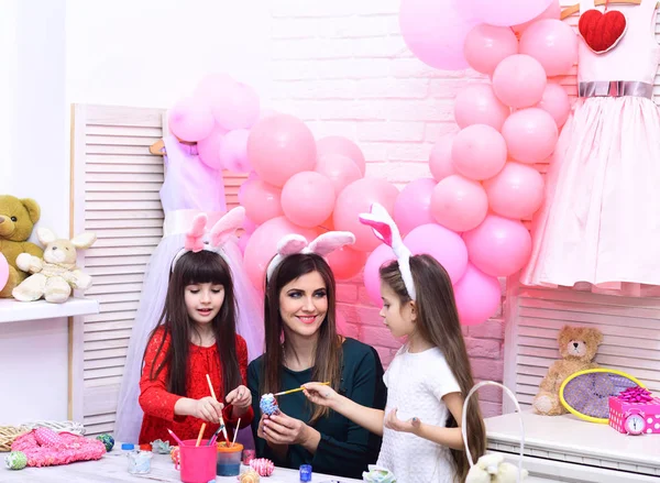 Mother and daughters paint handmade egg. — Stock Photo, Image