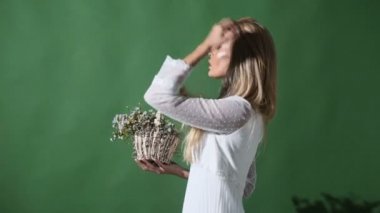 Zarif beyaz elbiseli sarışın genç kadın. Kız arka çanta ile poz. Bahar buket çiçek bayanla. Moda. Çiçekli Ukraynalı kız.