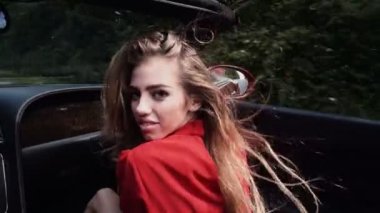 Güzel seksi kız manken lüks araba parlak makyaj ile. Güzel kadının Cabrio eski model araba yolculuk yolculuğa uzanmış kollarıyla.