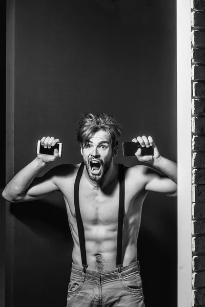 Hombre emocionado con dos teléfonos inteligentes —  Fotos de Stock