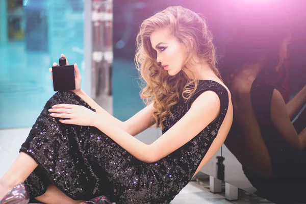 Perfume bottle in hands of sensual woman, perfumery