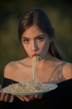 Açlık, iştah, tarifi. İtalyan makarna veya spagetti yemek, yemek. Diyet ve sağlıklı organik gıda, İtalya. Şef kadın kırmızı dudaklar ile makarna yemek. Çeşnicibaşı veya restoran eleştirmeni olarak makarna yemek kadın.