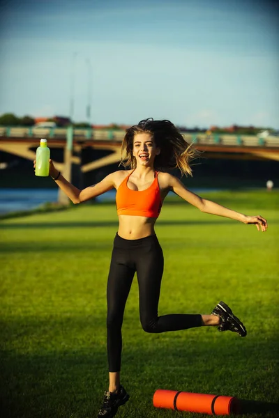 행복 한 여자 스포츠 병와 녹색 잔디, 에너지에 점프 — 스톡 사진