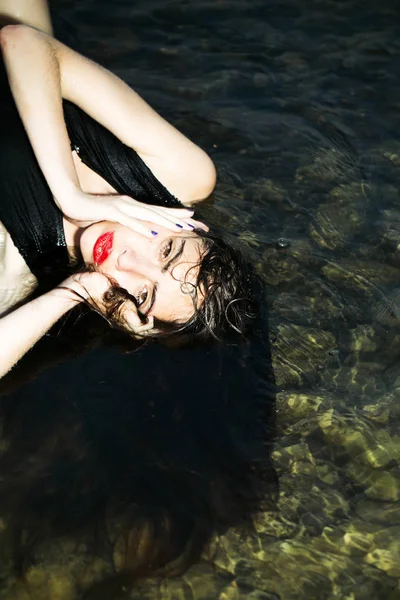 Beautiful young woman floating in water