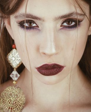 Makyaj ve takı küpe olan kadın. Son saatlerinde yanında bulunanlar ve Cilt Bakımı, Kuaför kozmetik. Güzellik ve Moda Aksesuar kız için. Moda makyaj ile şık kız görünümünü. Kadın yüz zarif makyaj ile.