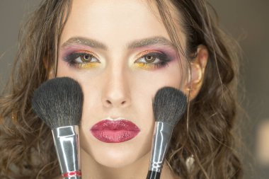 Güzellik kadın makyaj fırçaları ile son saatlerinde yanında bulunanlar. Güzellik modeli uygulamak toz yüzünde.