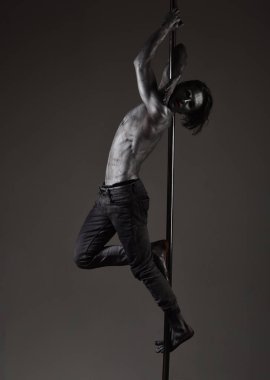 Metallis direğe asılı adam. Atlet, kutup dans performans sporcu