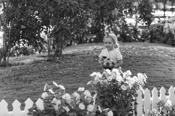 Feliz menino bonito jogando com bola na grama verde — Fotografia de Stock