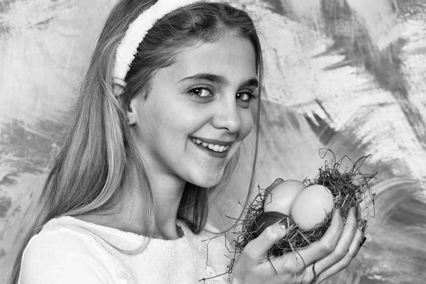 Ευτυχισμένος κορίτσι Πάσχα με πολύχρωμα βαμμένα αυγά στο άχυρο φωλιά — Φωτογραφία Αρχείου