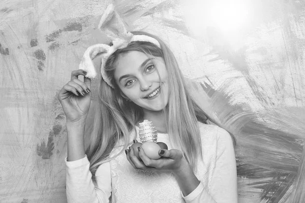 Chica feliz en orejas de conejo con coloridos huevos de Pascua pintados — Foto de Stock