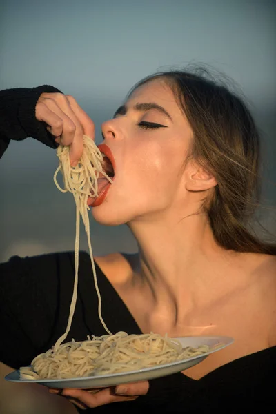 Honger, eetlust, recept. Voeding en gezonde natuurvoeding, Italië. Vrouw eten pasta als voorproefje of restaurant criticus. Chef-kok vrouw met rode lippen eten pasta. Italiaanse macaroni of spaghetti eten, koken. — Stockfoto