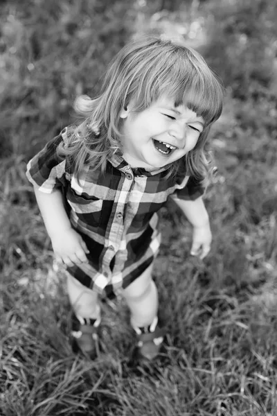 Glad liten pojke på grönt gräs — Stockfoto